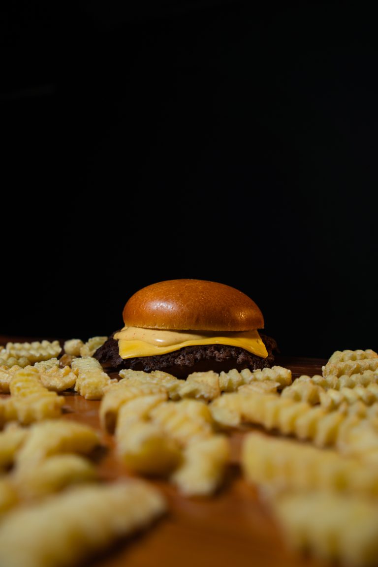 Cheeseburger cercado de batatas crinkle
