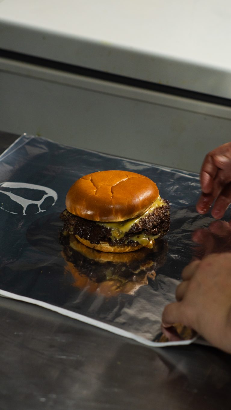 Cheeseburger pronto sobre papel alumínio na chapa