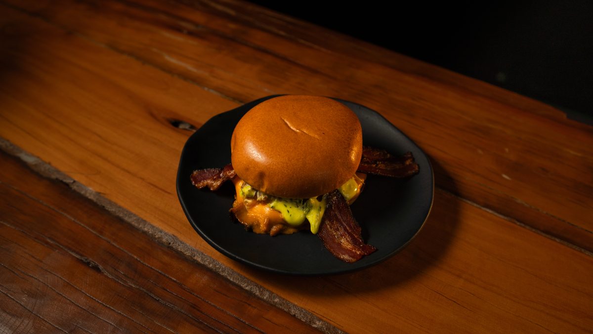 Hambúrguer com bacon crocante no prato preto