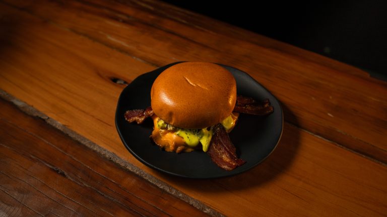 Hambúrguer com bacon crocante no prato preto